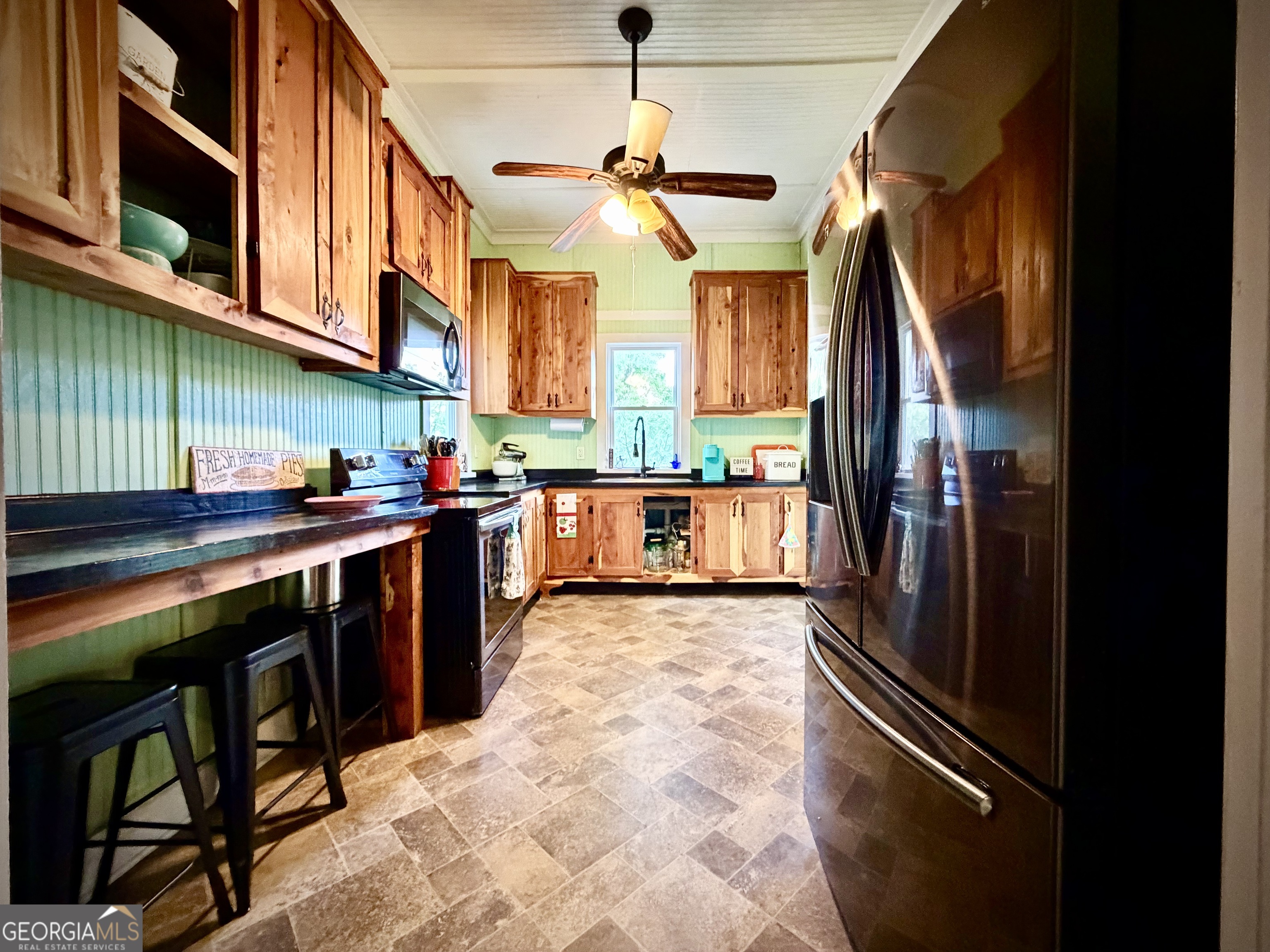 629 Bobby Fortner Road Kite, GA 31049 - Photo 15 of 63 a kitchen with stainless steel appliances granite countertop a refrigerator a sink dishwasher a stove and a dining table with wooden floor