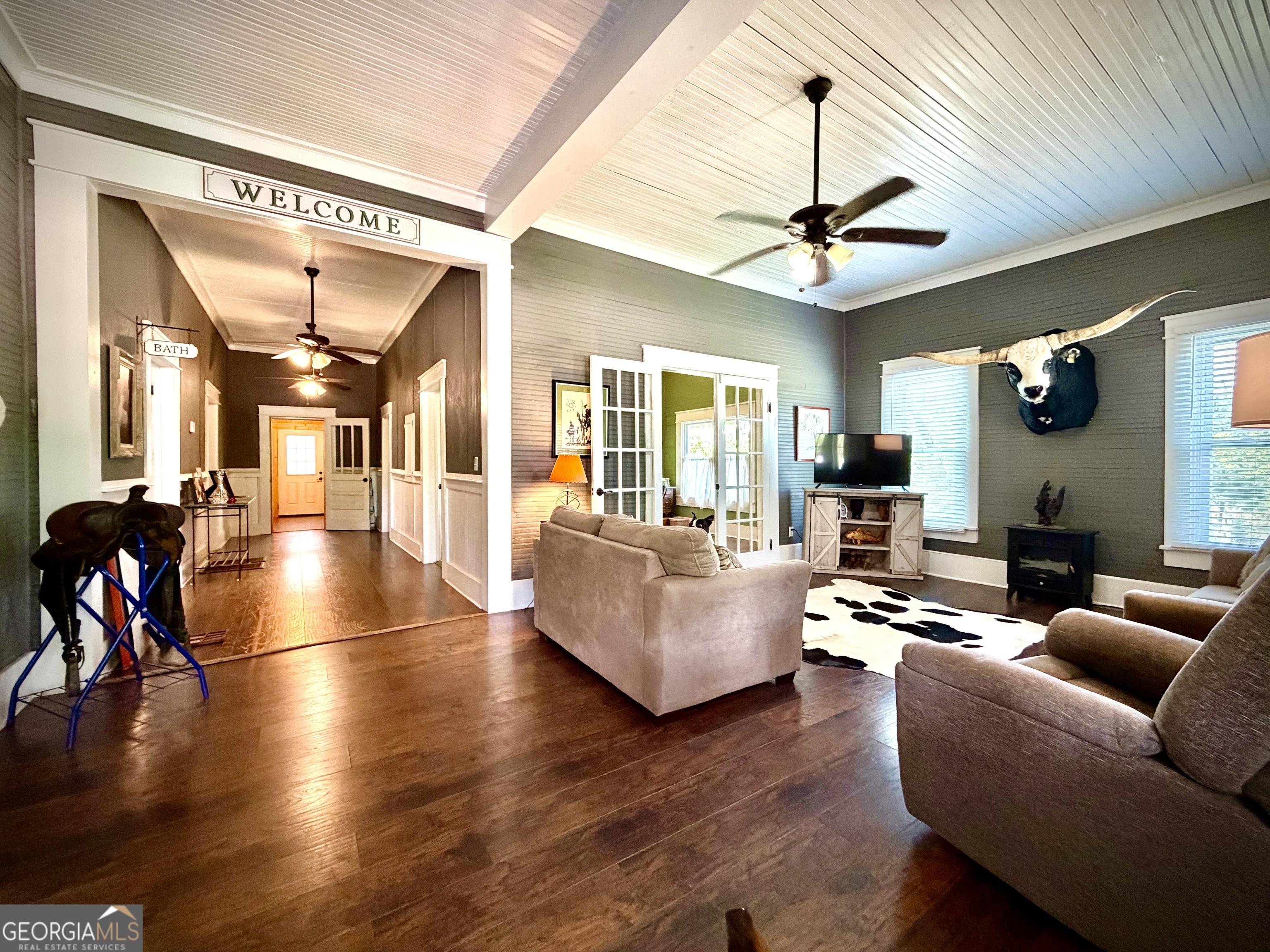 629 Bobby Fortner Road Kite, GA 31049 - Photo 6 of 63 a living room with couches a coffee table and a chandelier with wooden floor