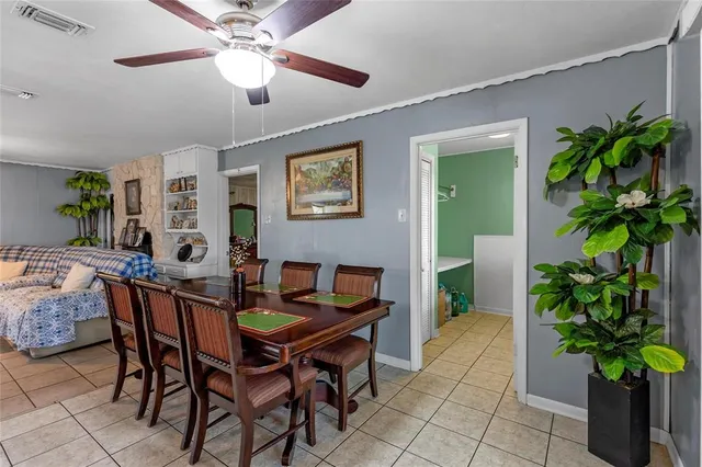 a dining room with furniture and a potted plant