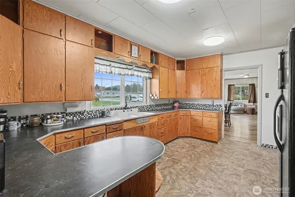a kitchen with stainless steel appliances granite countertop a sink and a refrigerator