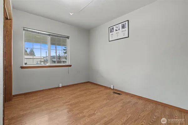 a view of empty room with wooden floor