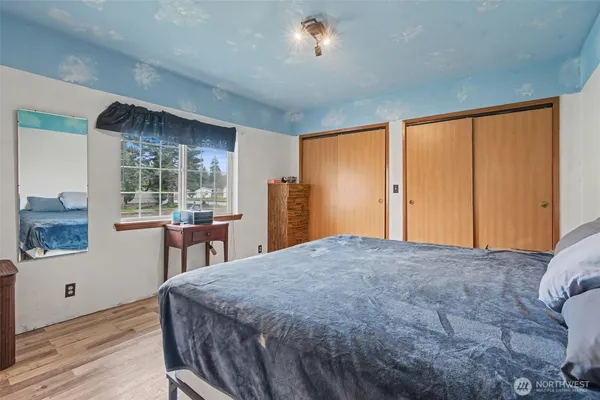 a bed sitting in a spacious bedroom next to a window