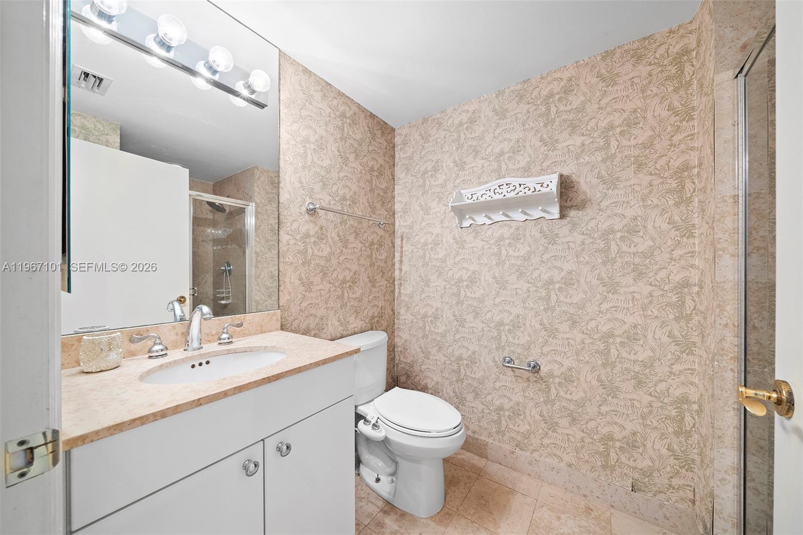 4775 Collins Avenue, Unit 1203 Miami Beach, FL 33140 - Photo 24 of 43 a bathroom with a toilet a sink a mirror and a shower