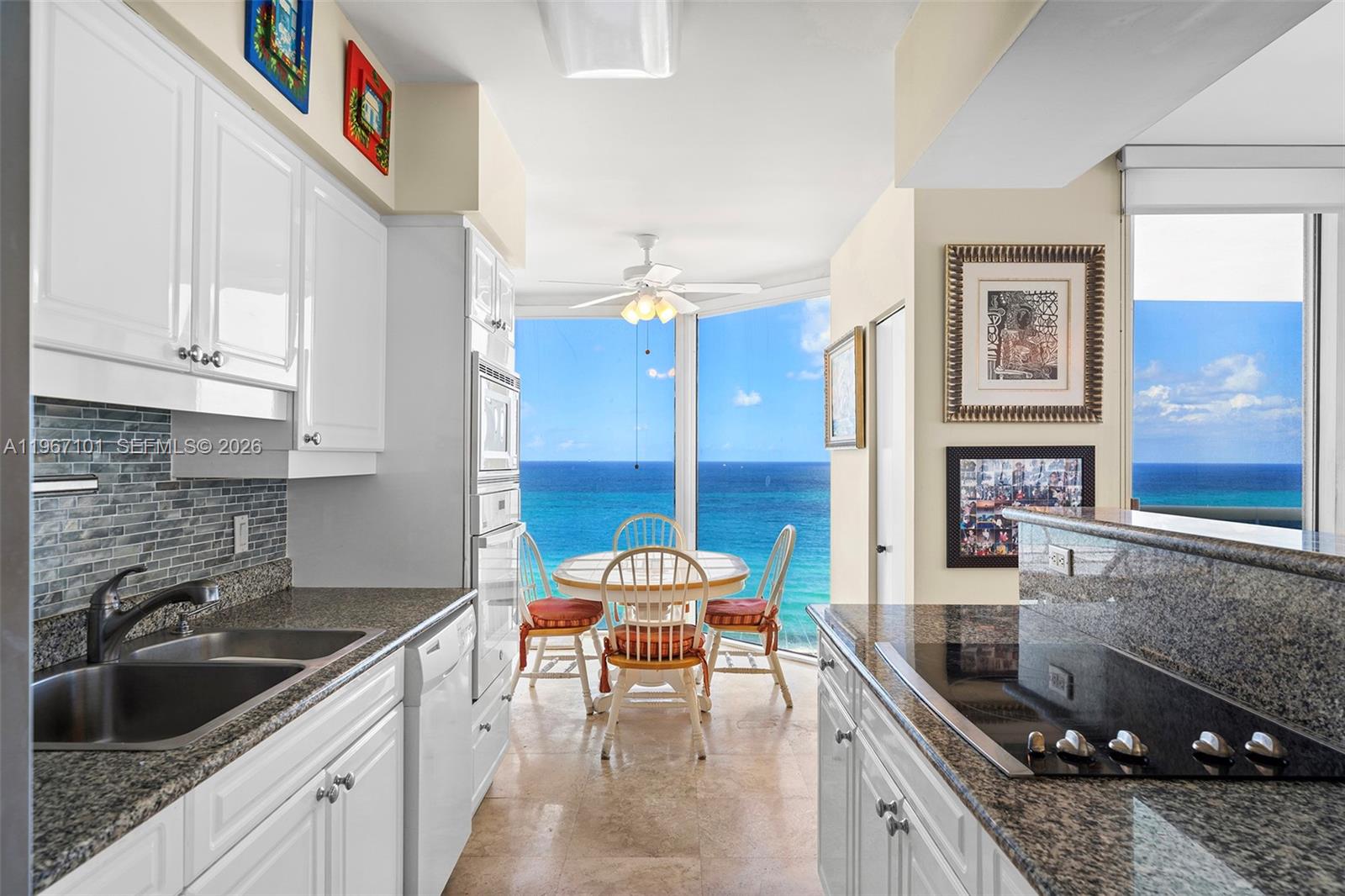 4775 Collins Avenue, Unit 1203 Miami Beach, FL 33140 - Photo 6 of 43 a kitchen with a sink stove and cabinets
