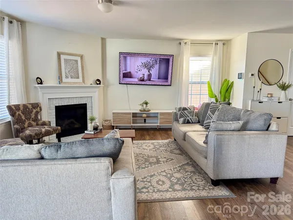 a living room with furniture a fireplace and a large mirror