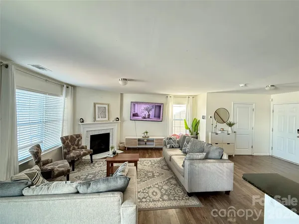 a living room with fireplace furniture and a large window