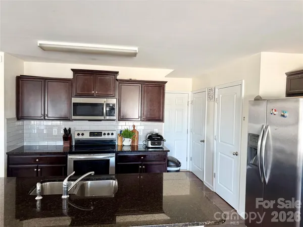 a kitchen with stainless steel appliances granite countertop a refrigerator and a stove