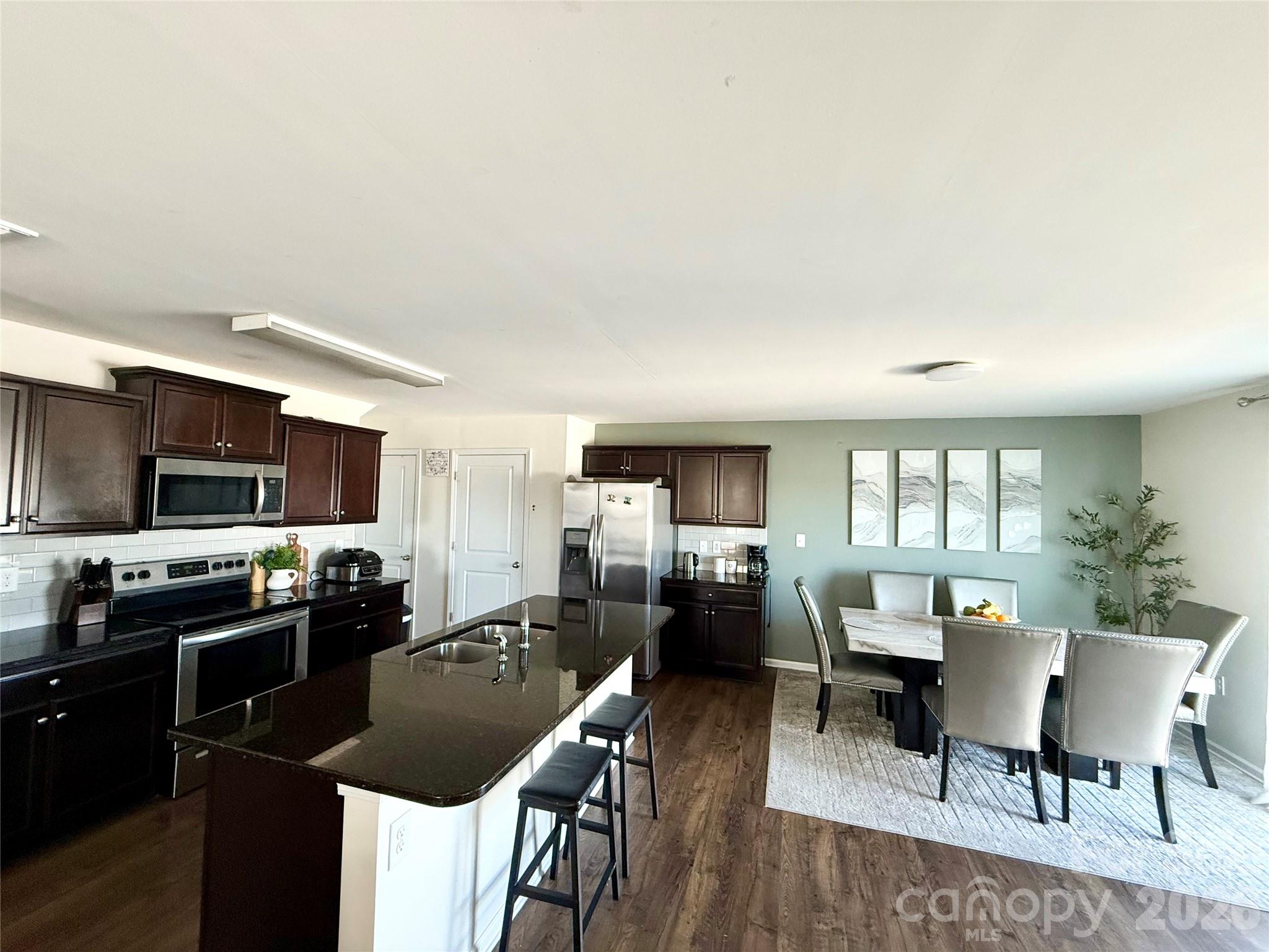 4018 BETHESDA Place Concord, NC 28025 - Photo 9 of 21 a kitchen with sink refrigerator dining table and chairs