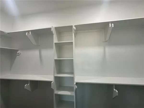 an empty room with wooden floor ceiling fan and windows