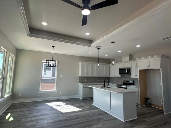 a kitchen with stainless steel appliances kitchen island granite countertop a stove a sink and a refrigerator
