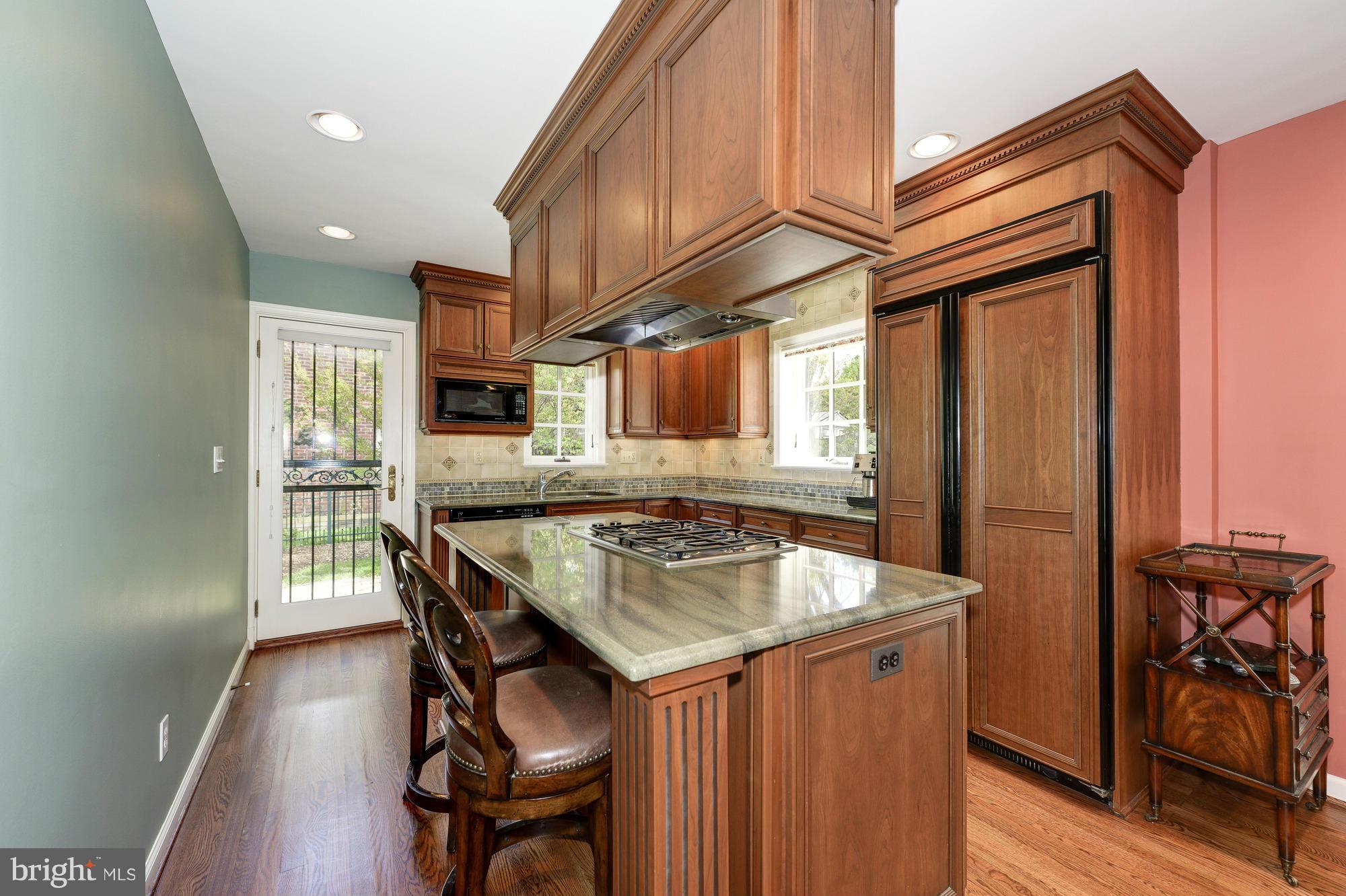 6752 Little Falls Road Arlington, VA 22213 - Photo 4 of 30 a kitchen with stainless steel appliances granite countertop a kitchen island a stove a table and chairs