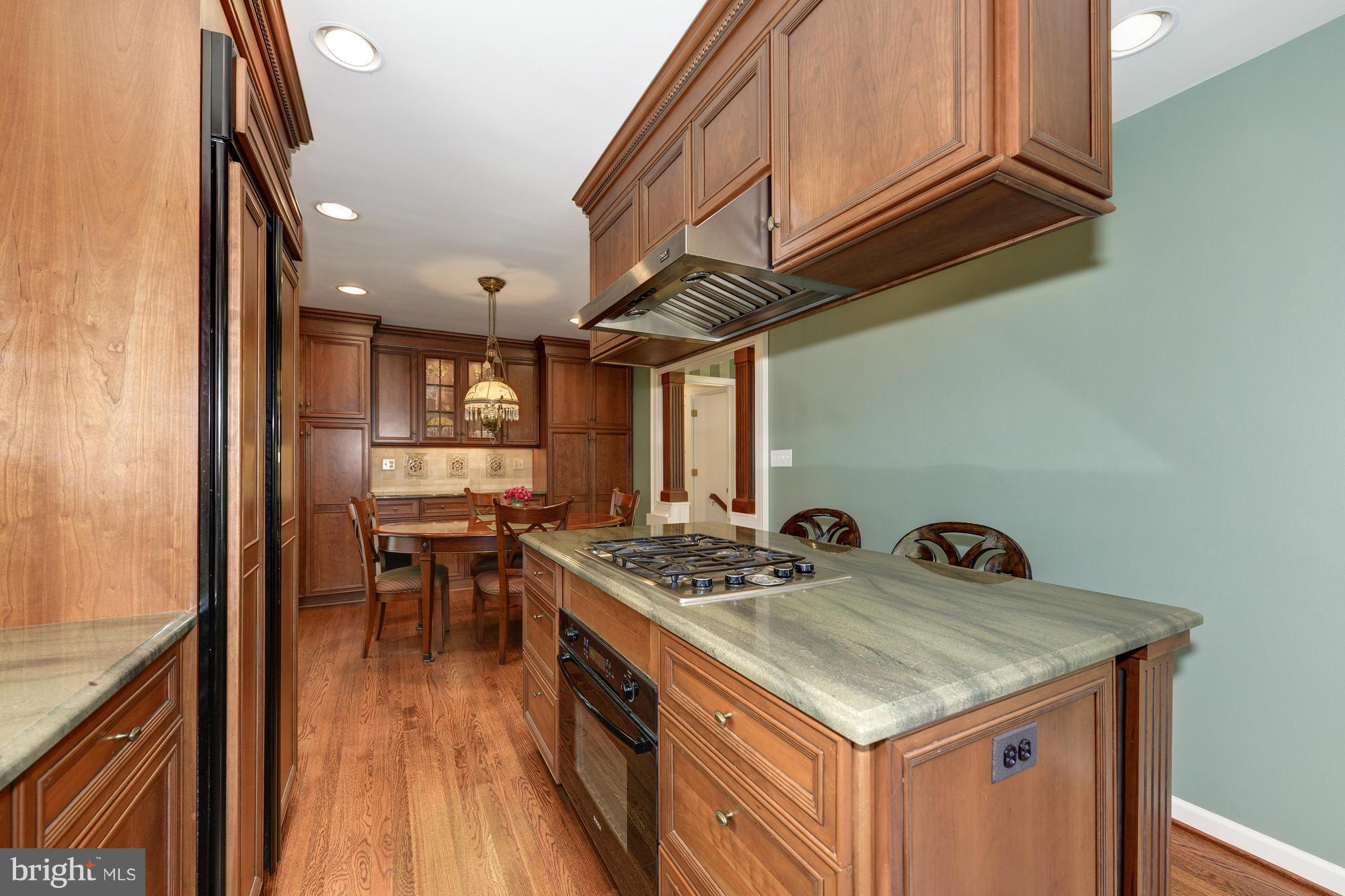 6752 Little Falls Road Arlington, VA 22213 - Photo 6 of 30 a kitchen with a stove and a wooden floor