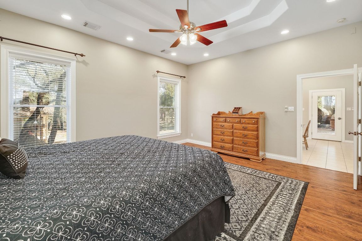 200 High River Ranch Drive Liberty Hill, TX 78642 - Photo 14 of 39 a bedroom with a bed and dresser with wooden floor