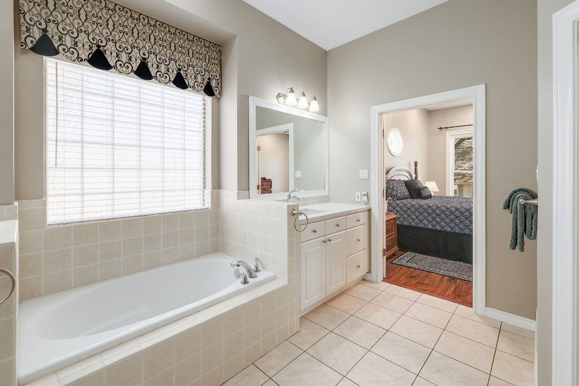 200 High River Ranch Drive Liberty Hill, TX 78642 - Photo 16 of 39 a bathroom with a bathtub and a double vanity sink mirror