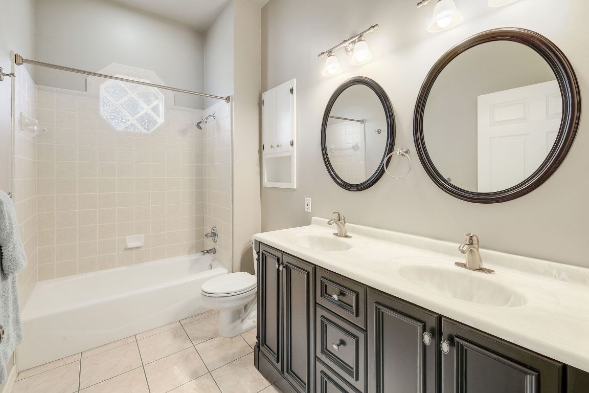200 High River Ranch Drive Liberty Hill, TX 78642 - Photo 22 of 39 a bathroom with a granite countertop toilet a sink and a mirror
