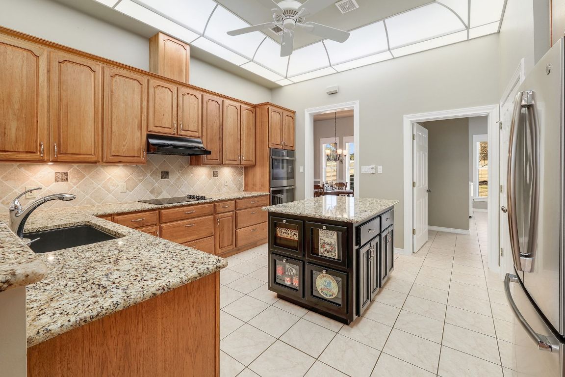 200 High River Ranch Drive Liberty Hill, TX 78642 - Photo 8 of 39 a kitchen with stainless steel appliances granite countertop a stove a sink and a microwave