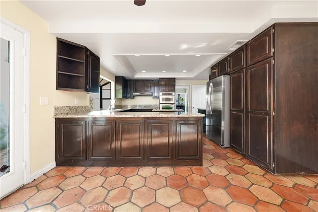 a kitchen with granite countertop a refrigerator and a sink