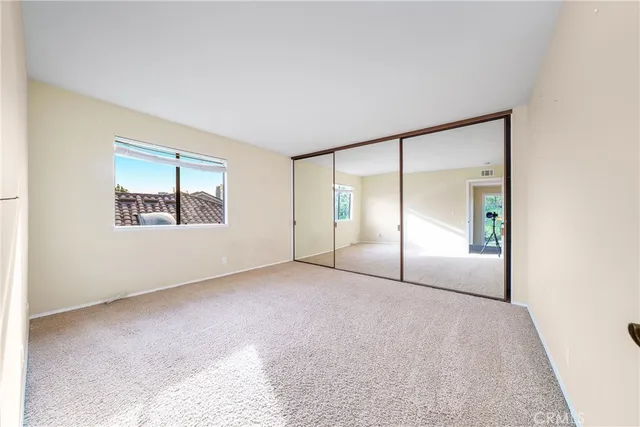 an empty room with windows and closet