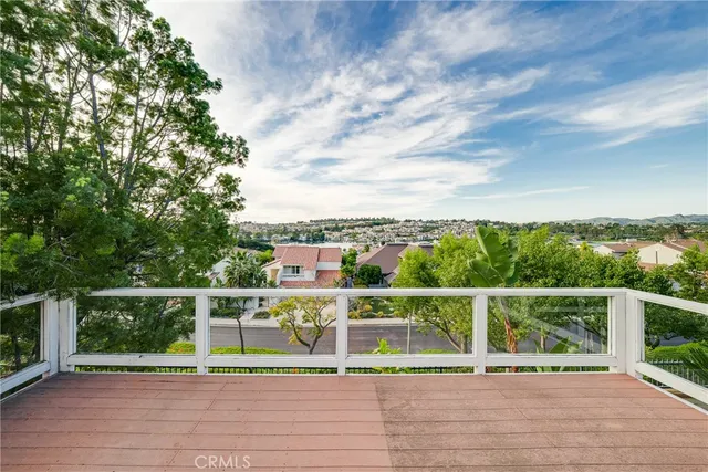 a view of a balcony with wooden floor and fence
