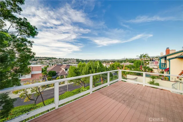a view of a balcony with wooden floor and fence
