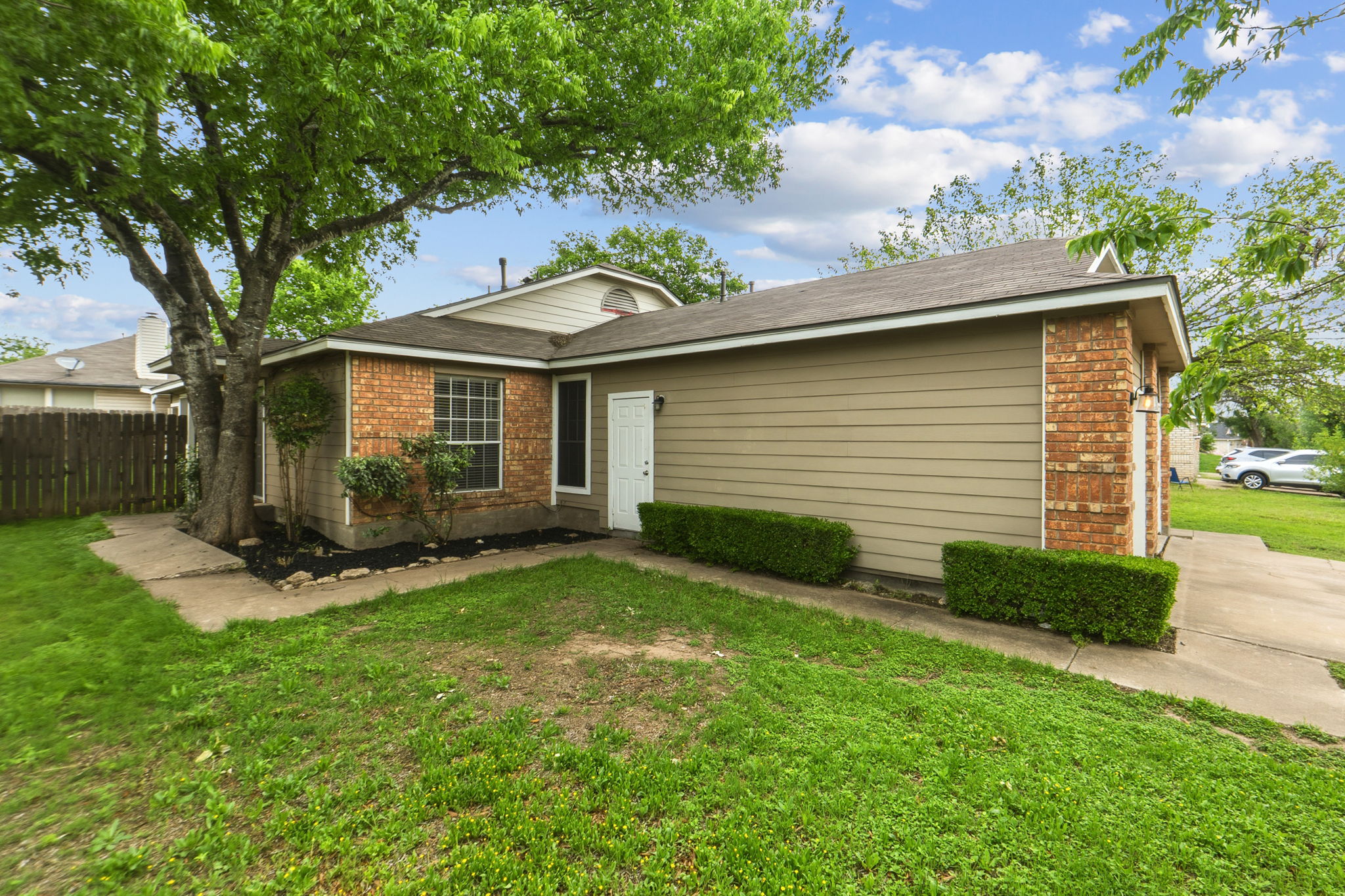 2302 Fuzz Fairway, Unit A Austin, TX 78728 - Photo 5 of 32 a view of a backyard with plants and a large tree