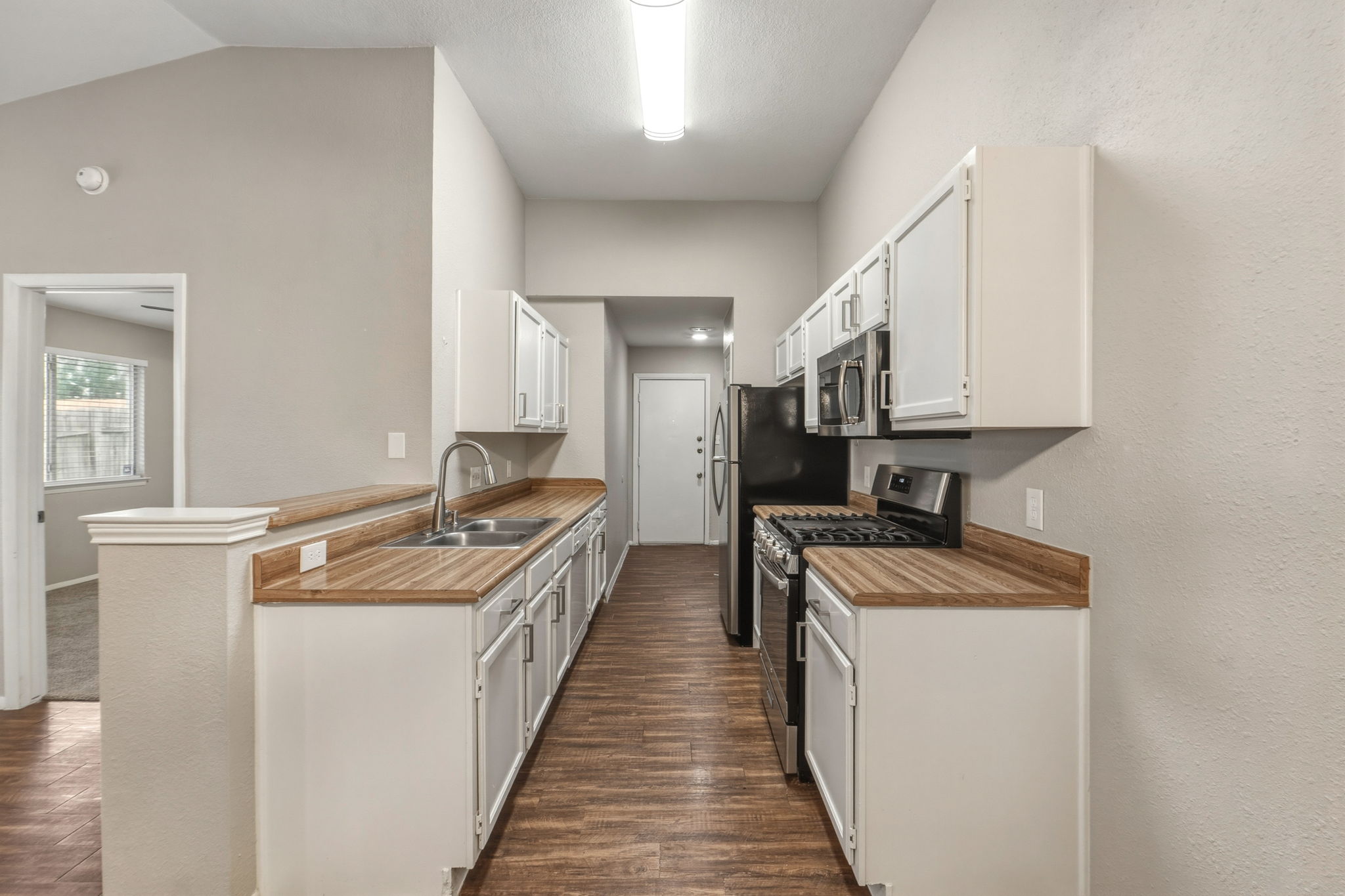 2302 Fuzz Fairway, Unit A Austin, TX 78728 - Photo 7 of 32 a kitchen with stainless steel appliances granite countertop lots of counter top space and a sink