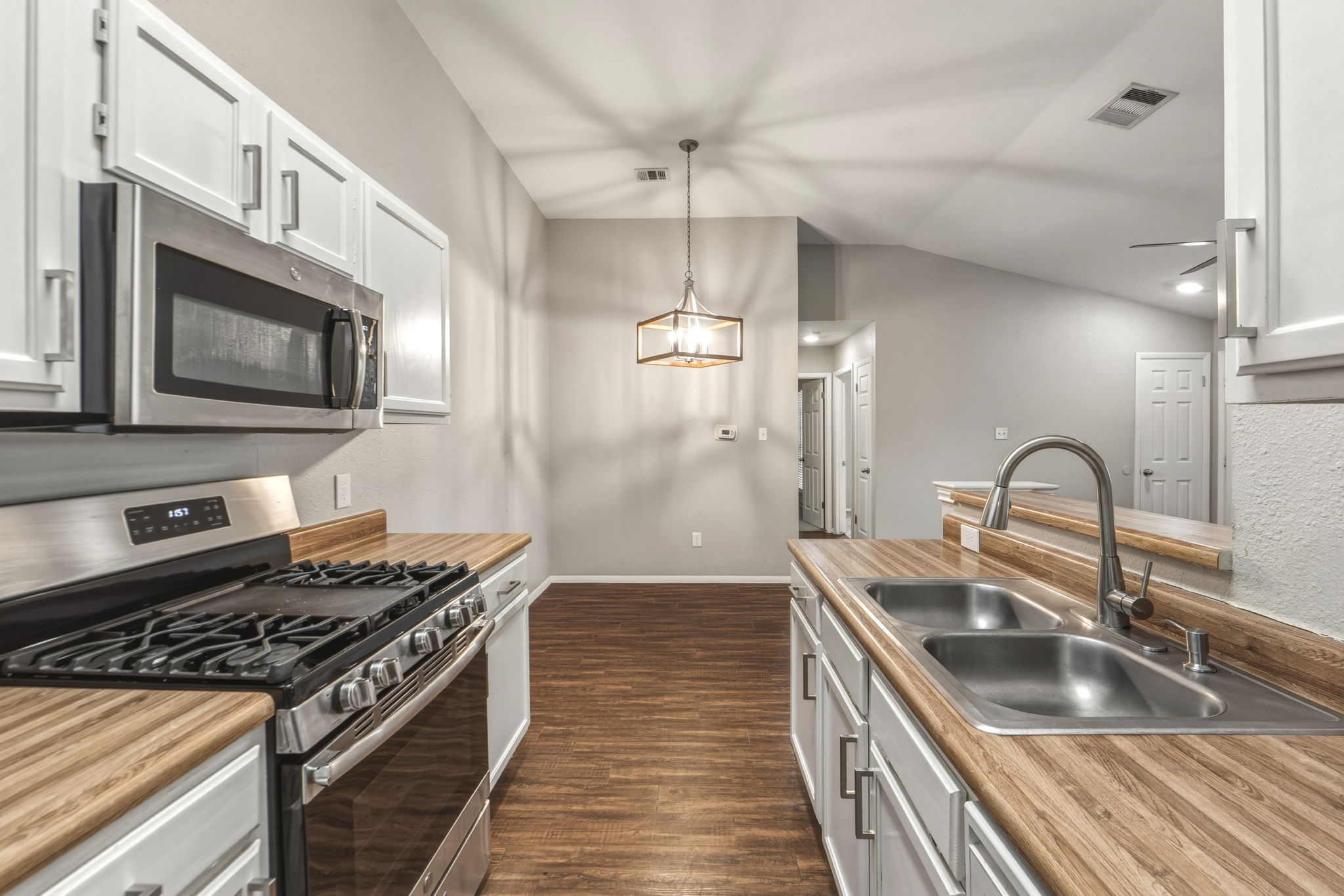 2302 Fuzz Fairway, Unit A Austin, TX 78728 - Photo 10 of 32 a kitchen with kitchen island granite countertop a sink stainless steel appliances and cabinets