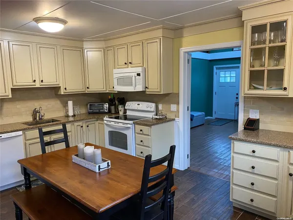 a kitchen with a wooden floor and white appliances