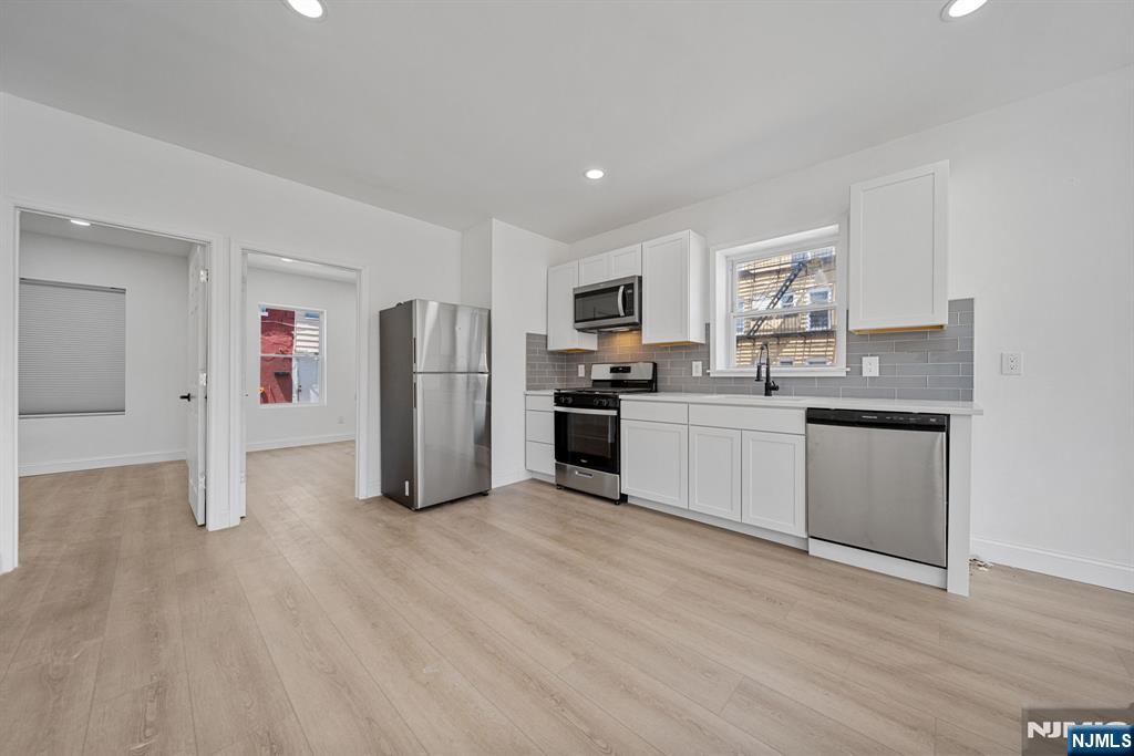 61 Farnham Avenue, Unit 1 Garfield, NJ 07026 - Photo 2 of 14 a kitchen with stainless steel appliances a sink and a refrigerator