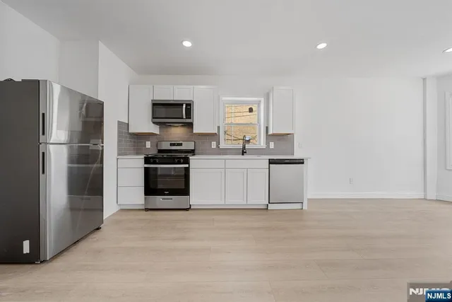 a kitchen with a refrigerator and a stove top oven