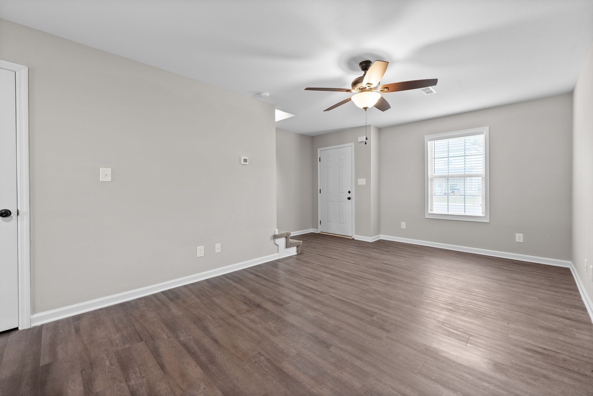 418 Peachers Mill Road, Unit G9 Clarksville, TN 37042 - Photo 6 of 21 an empty room with wooden floor ceiling fan and windows