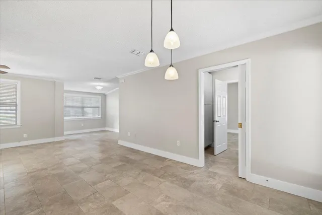 a view of an empty room with window and cabinet