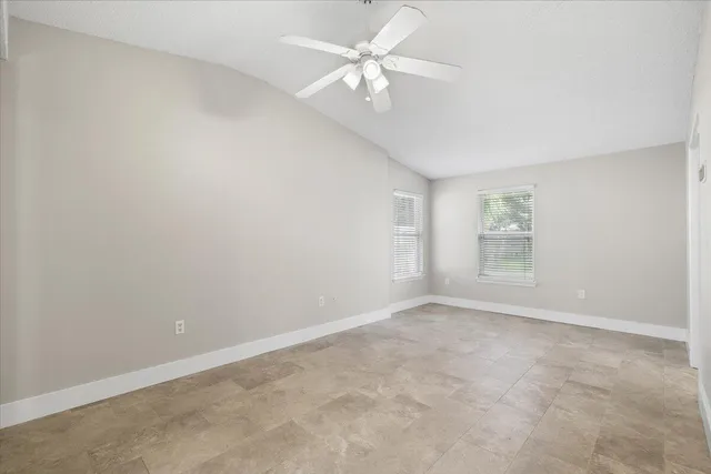 an empty room with a window and a fan