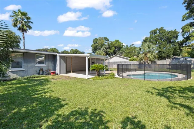 a view of a house with backyard and a tree