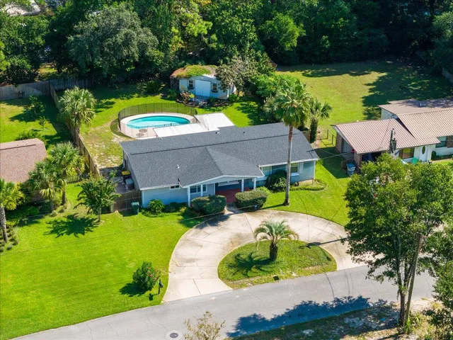 an aerial view of a house with swimming pool and outdoor seating