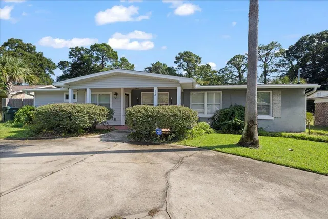 a view of a house with a yard and potted plants