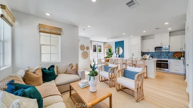 a living room with fireplace furniture and kitchen view