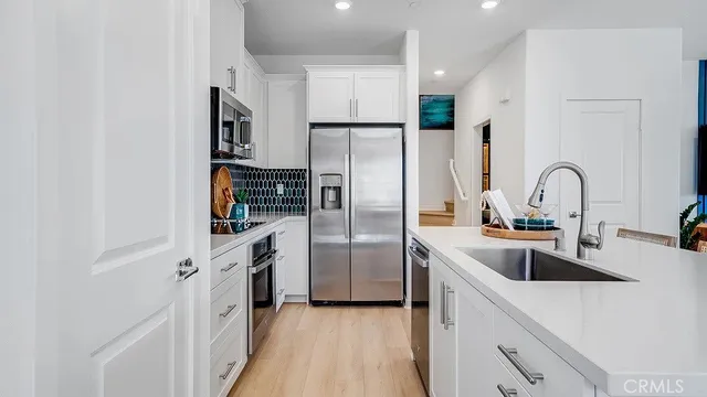 a kitchen with stainless steel appliances a refrigerator sink and cabinets