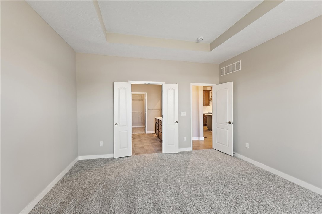 407 South Landon Lane Springfield, OH 45502 - Photo 11 of 30 This spacious primary bedroom features soft carpeting and a beautiful tray ceiling.