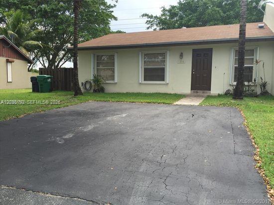 11206 Southwest 125th Place, Unit 11206 Miami, FL 33186 - Photo 1 of 15 a view of a house with a yard and large tree