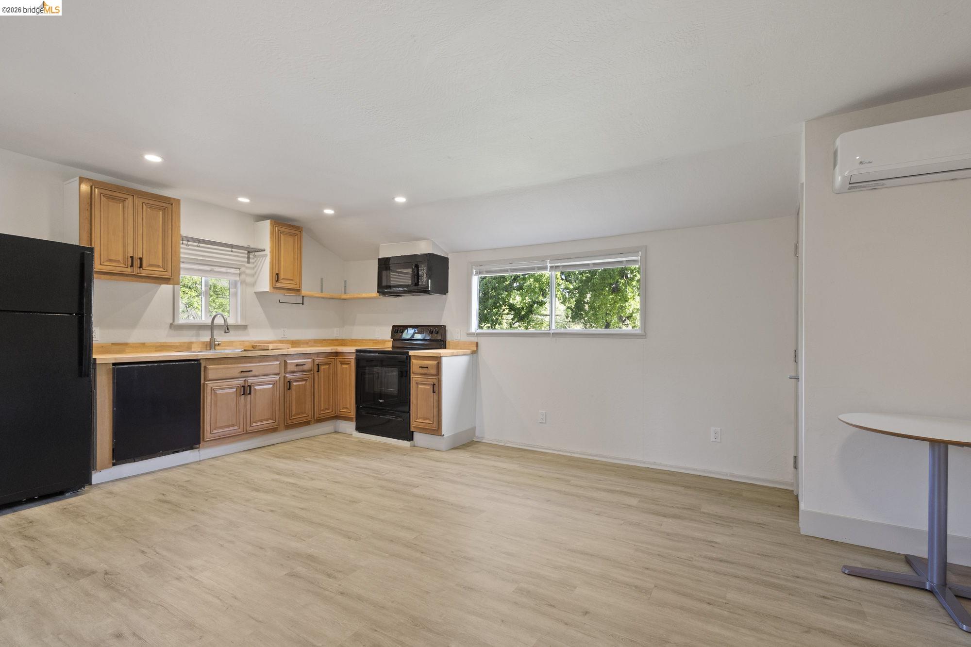 18363 Yosemite Road Tuolumne, CA 95379 - Photo 23 of 34 Open-concept kitchen with light wood-finish cabinetry, black appliances, and recessed lighting