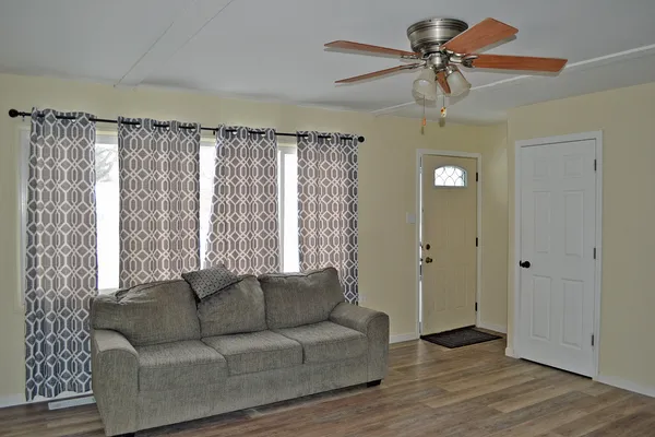 a living room with furniture and a ceiling fan