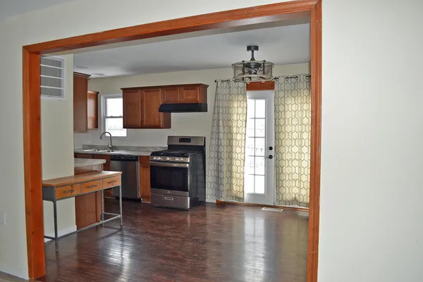 a kitchen with granite countertop a stove and a wooden floors