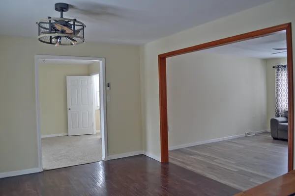 an empty room with wooden floor and a window