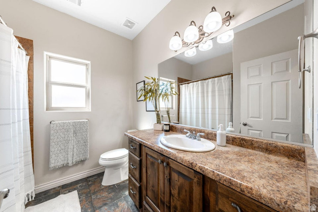 7776 Wagon Road East St. George, UT 84770 - Photo 30 of 76 Full bathroom featuring vanity, dark stone finish floors, and a shower with shower curtain