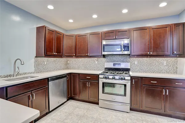 a kitchen with stainless steel appliances granite countertop wooden cabinets stove top oven and sink
