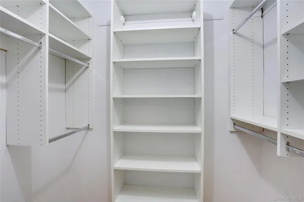 a view of walk in closet with empty racks