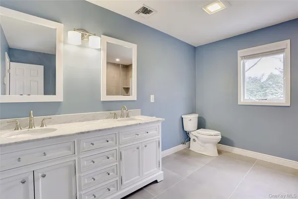 a bathroom with a toilet a sink and mirror