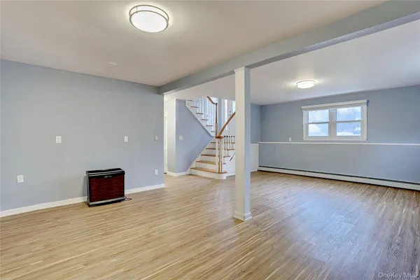 an empty room with wooden floor and stairs