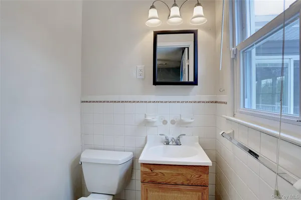 a bathroom with a toilet sink and mirror